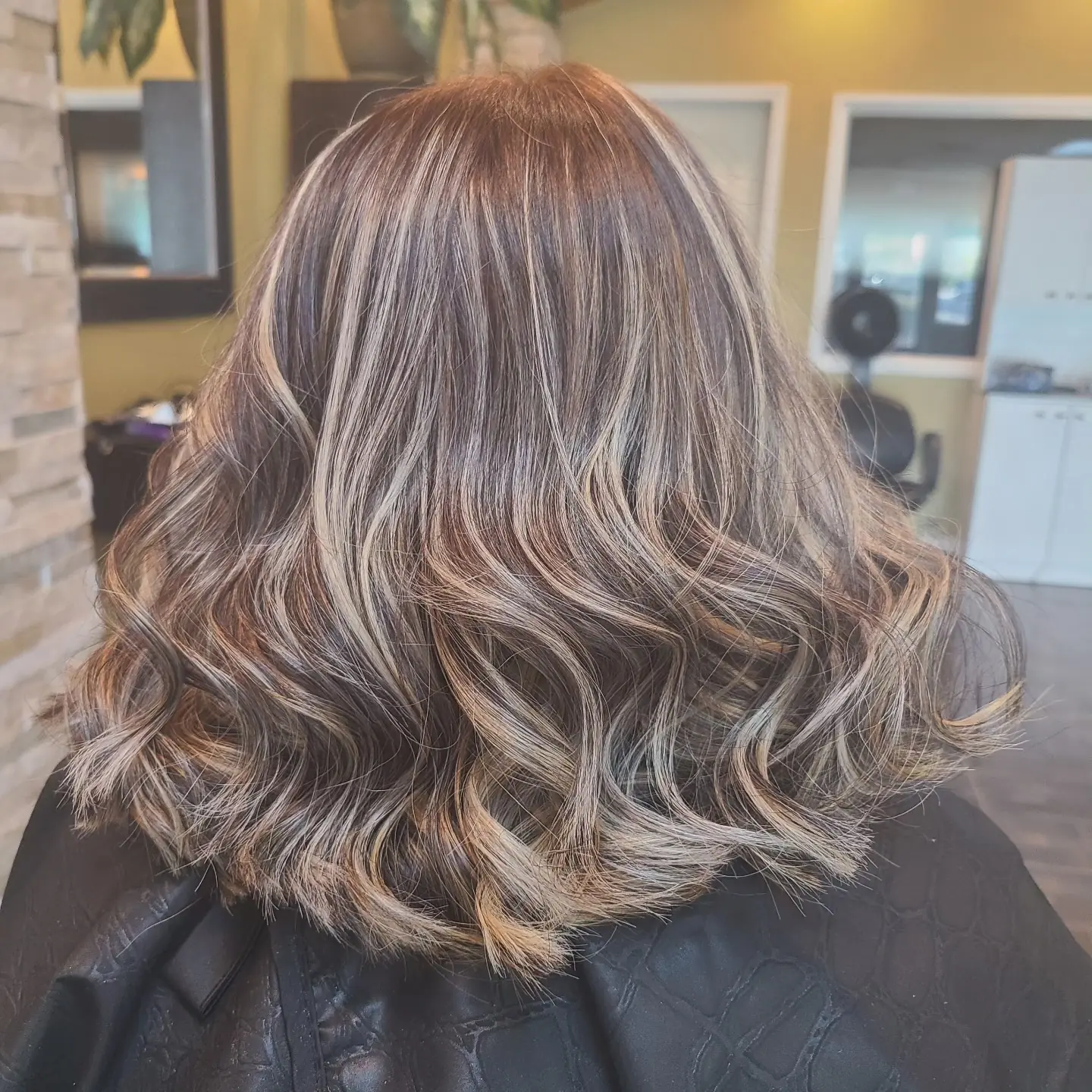 Contrasting blonde highlights on wavy mid-length hair at GMS Beauty Salon