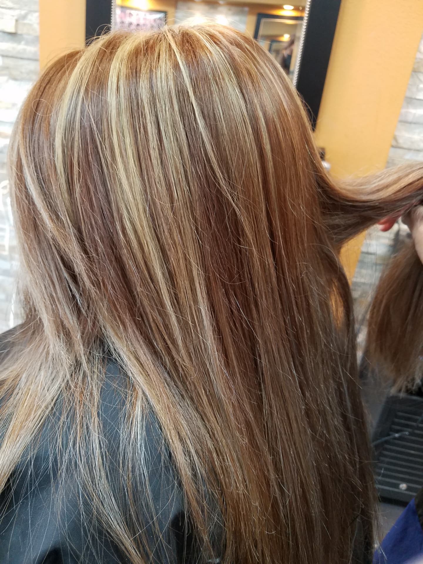 Blonde and caramel highlights on long hair, viewed from behind at GMS Beauty Salon